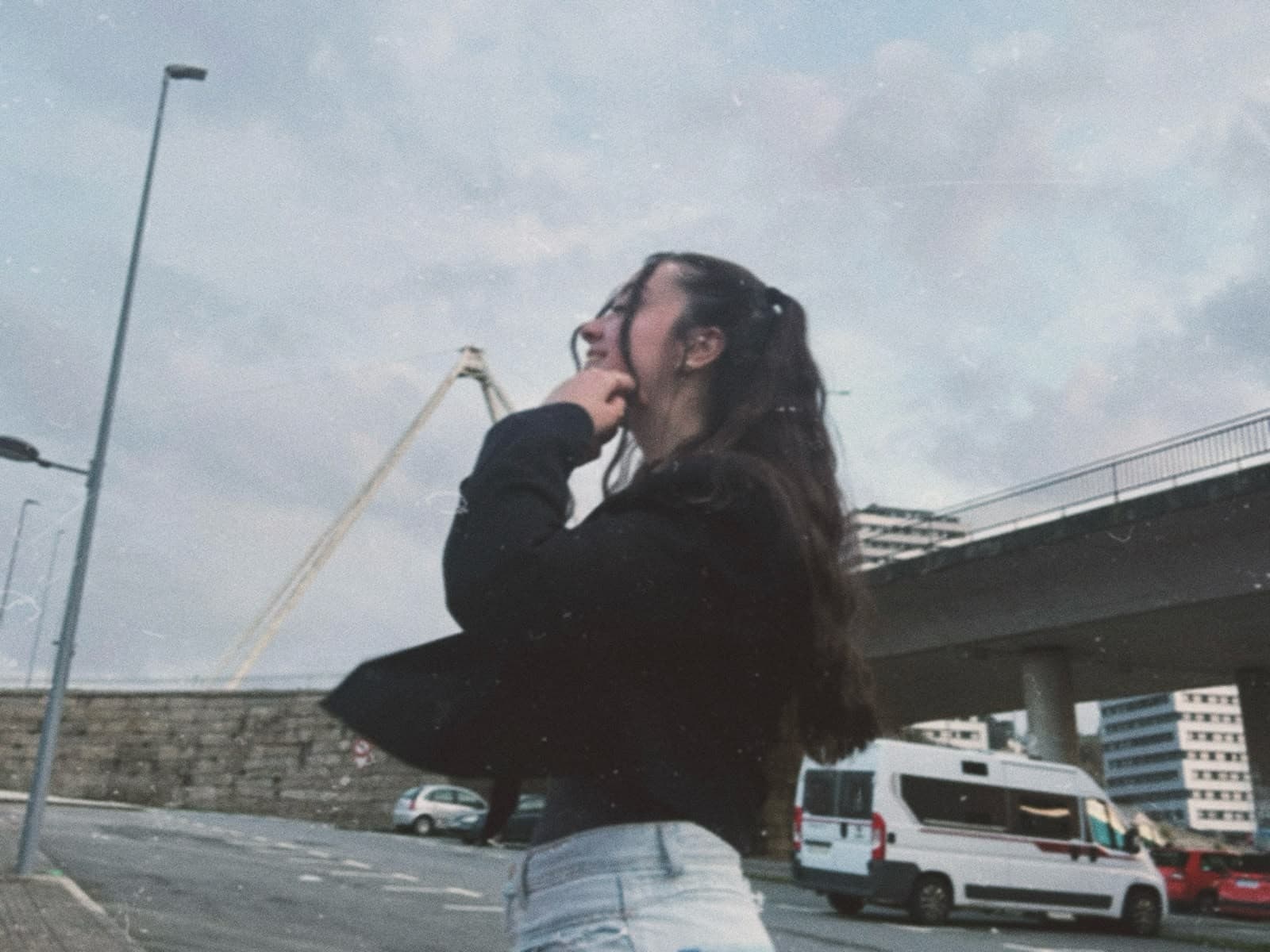 Diana Mascareñas mirando hacia arriba, con un puente y una grúa de construcción al fondo